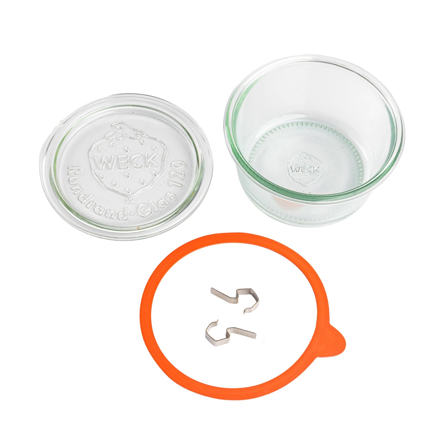 Разобранные элементы круглой стеклянной банки Weck: прозрачная крышка с гравировкой логотипа Weck, оранжевый силиконовый уплотнитель, металлические зажимы на белом фоне