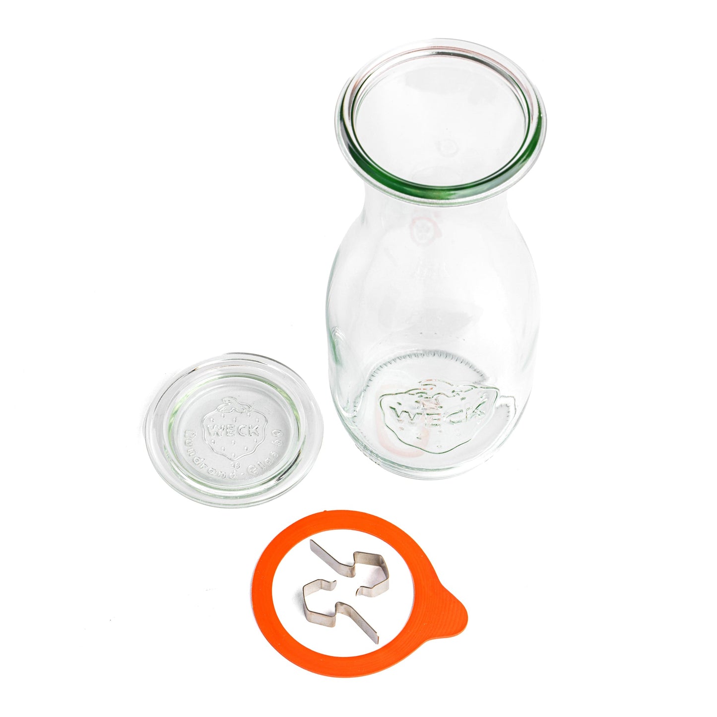Стеклянная банка WECK с вытянутой формой, разобранная на части, вид сверху. Отдельно лежащая крышка с гравировкой WECK, оранжевая уплотнительная резинка и металлические зажимы, на прозрачном фоне.